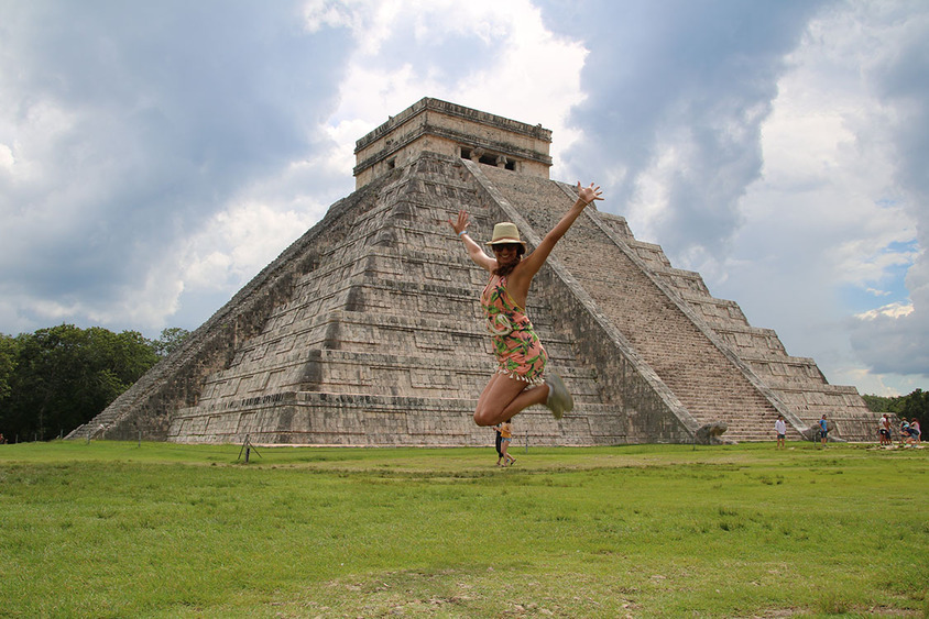 portrait-happy-woman-jumping-el-castillo-against-cloudy-sky