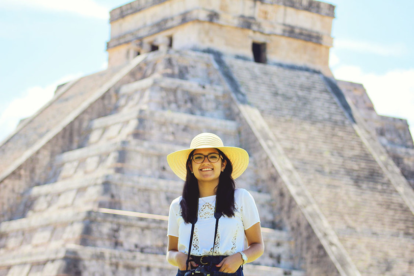 portrait-smiling-young-woman-wearing-hat-while-standing-against-monument